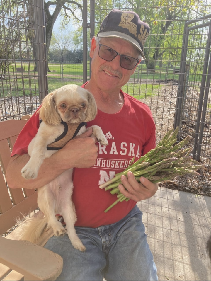 Tim Lambert of Lambert Melons with his dog and a bundle of asparagus